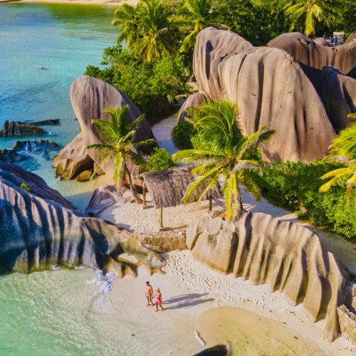 Anse Source d'Argent beach, La Digue Island, Seyshelles, Drone aerial view of La Digue Seychelles bird eye view.of tropical Island, couple men and woman walking at the beach during sunset at a luxury vacation